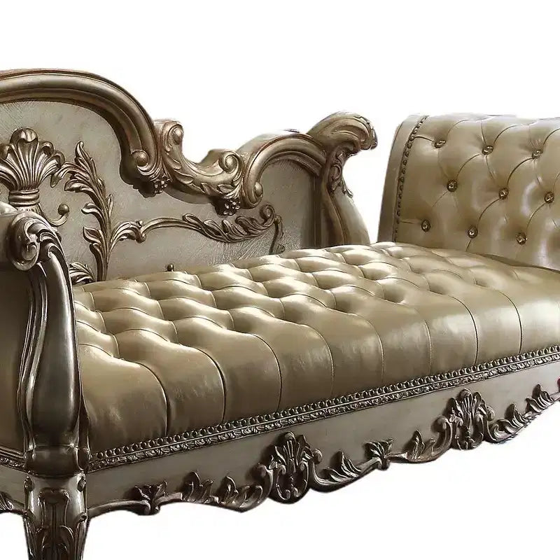 Panca d'appoggio in similpelle trapuntata, struttura in legno con patina dorata, borchie decorative e piedini a zampa di leone