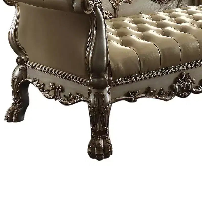 Panca d'appoggio in similpelle trapuntata, struttura in legno con patina dorata, borchie decorative e piedini a zampa di leone