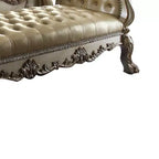 Panca d'appoggio in similpelle trapuntata, struttura in legno con patina dorata, borchie decorative e piedini a zampa di leone